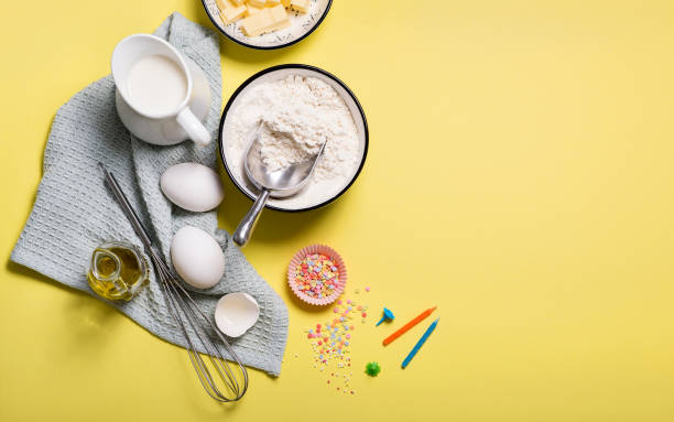 istock Baking ingredients for birthday cake on yellow copy space background 1162184700
