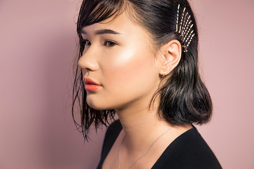 Portrait of Asian girl on pink background.