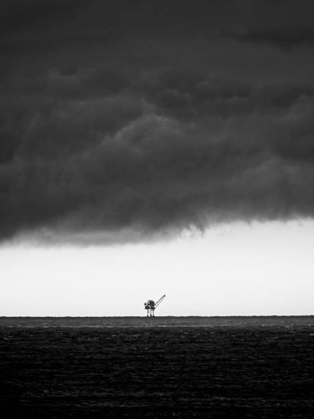 ölplattform mit sturmwolken 3 b&w - oil rig sea oil storm stock-fotos und bilder