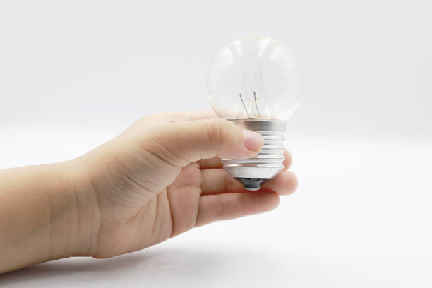 istock Kids hand holding a light bulb isolated on white background. 1162188557