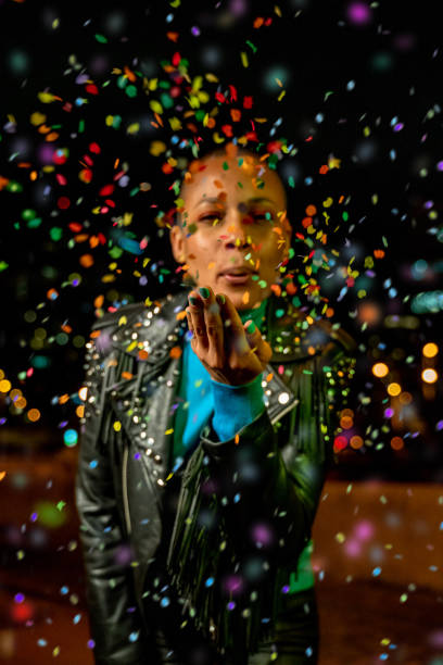istock Woman blowing confetti outdoors 1162190648