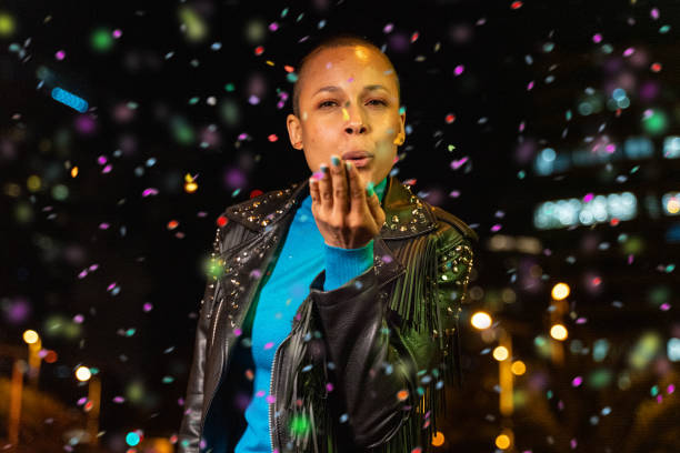 istock Woman blowing confetti outdoors 1162190653