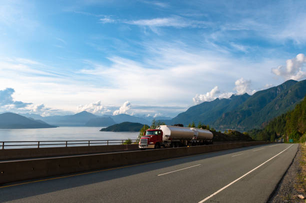 Fuel tanker driving along a coastal highway Double trailer fuel tanker driving along a scenic coastal highway. Transport truck driving along highway 99 or the Sea to Sky highway. fuel truck photos stock pictures, royalty-free photos & images