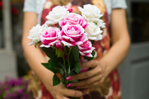 Beautiful florist woman holding a bouquet of fresh rose flowers