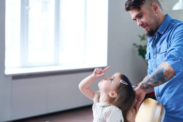 istock Man brushing hair of charming daughter 1162196317