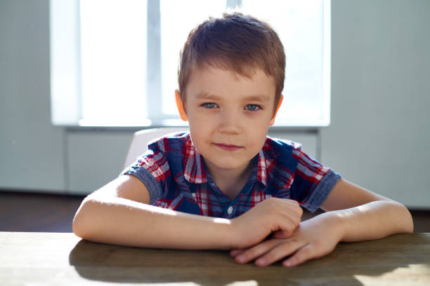 istock Casual boy sitting at table in sunlight 1162200444
