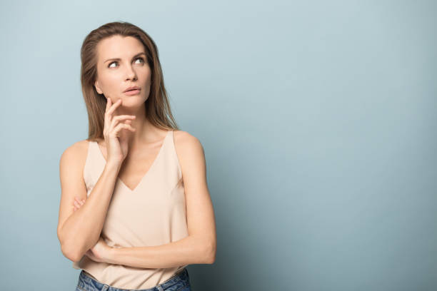 istock Attractive young woman touching her cheek, dreaming. 1162203081