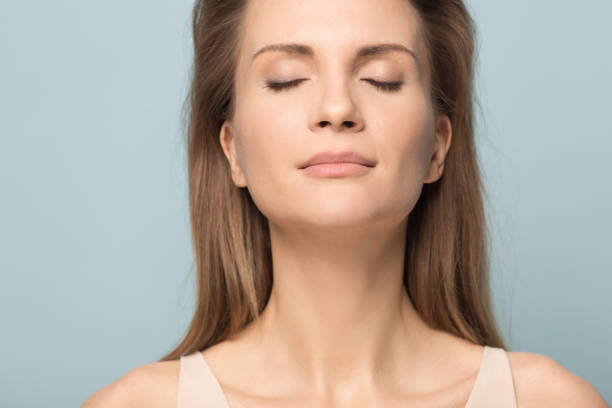 Close up young woman with closed eyes relaxing and breathing. Close up millennial calm attractive woman inhaling fresh air, breathing, relaxing with closed eyes, meditating, visualizing future, reminding pleasant positive memories, isolated on studio background. hysteria stock pictures, royalty-free photos & images