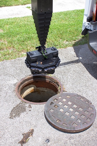 Inspection camera being lowered into sewer manhole for 3d digital examination
