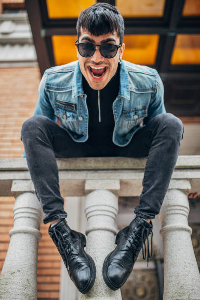 istock Cheerful guy sitting on fence 1162206849