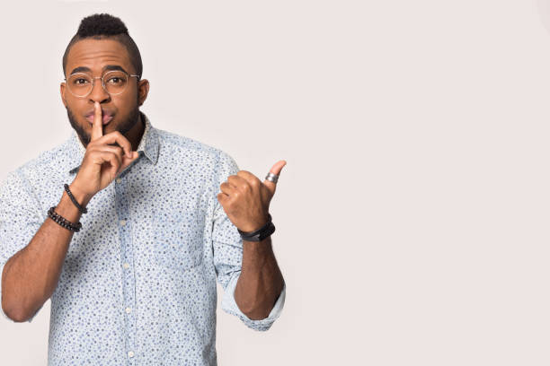 istock African guy isolated on studio background showing hush gesture 1162206892