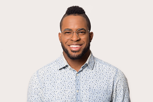 Headshot portrait african man in glasses smiling looking at camera