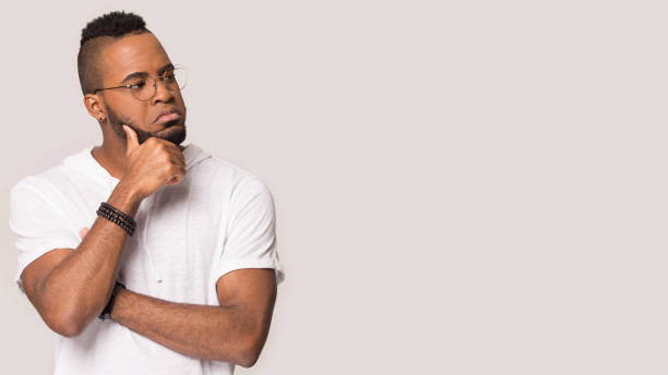 istock Pensive focused african guy look aside at copyspace studio shot 1162206915