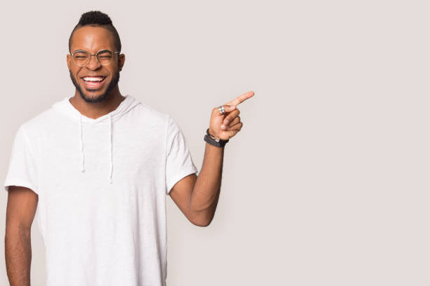 istock African guy laughing pointing finger aside at copyspace studio shot 1162206917