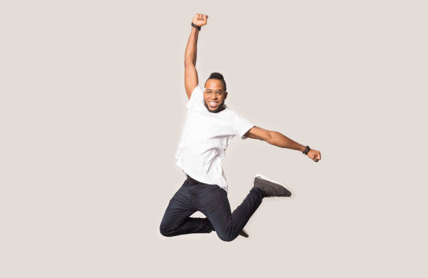 istock Happy joyful black man jumping high in photo studio. 1162206926