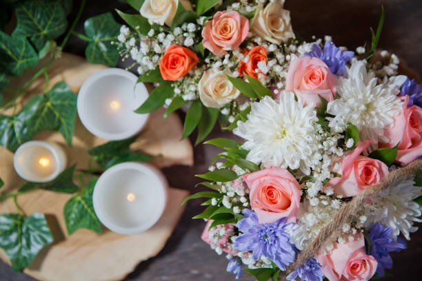 istock White , Pink roses, purple and candles on white candles background. Selective focus. Multi-colored flower bouquet, candles in the background. 1162208390