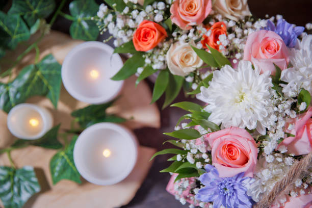 istock White , Pink roses, purple and candles on white candles background. Selective focus. Multi-colored flower bouquet, candles in the background. 1162208426
