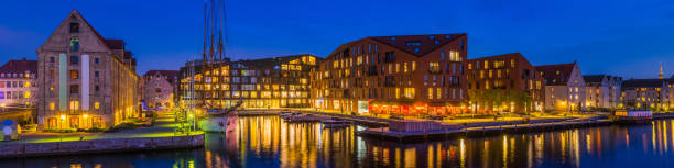 Panoramic view at night across the redeveloped warehouse buildings along the harbour waterfront in central Copenhagen, Denmark’s vibrant capital city.