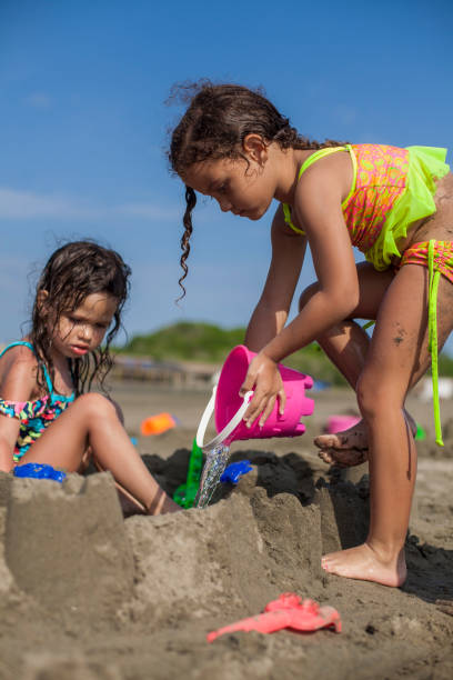 istock Two girls building sandcastles 1162212070
