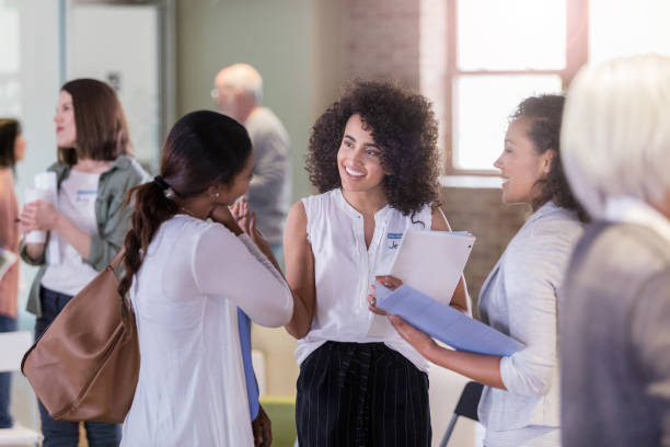 istock Before community meeting, three women smile and talk 1162212437
