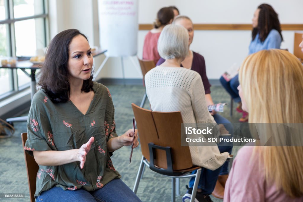Women break into small groups to share information Women break into small groups to better communicate information about breast cancer. Determination Stock Photo