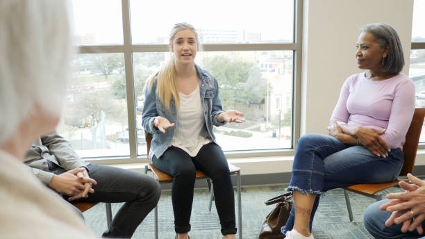 istock Teen girl gestures while she shares experiences with group 1162213355