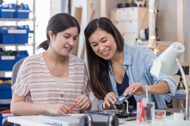 istock Mid adult mom instructs daughter while repairing laptop 1162213435