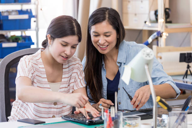 istock Mom encourages daughter while repairing computer 1162213439