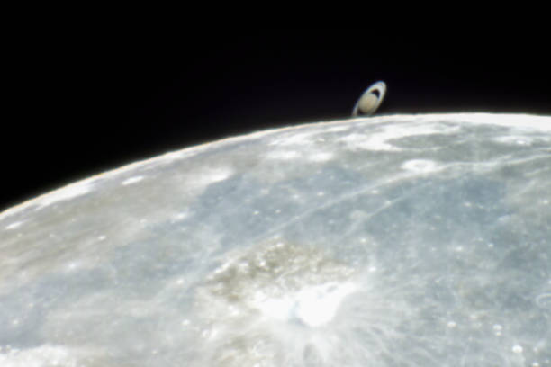 istock An amazing astronomy event, Saturn covered by the Moon surface awe night sky view from Santiago, Chile, polluted skies with an advanced amateur telescope. Saturn and its rings eclipse by the Moon 1162215135