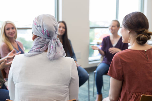 Women in circle talk about life with breast cancer The women meet to talk about how breast cancer has impacted their lives. womens issues stock pictures, royalty-free photos & images