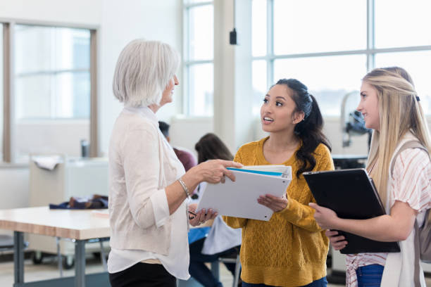 istock Teacher assists female high school students 1162215483