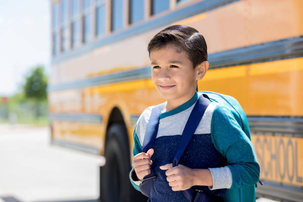 istock Young boy waits to board school bus 1162215669