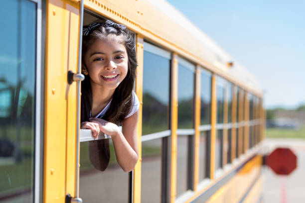 istock Cute elementary schoolgirl looking out of bus window 1162215688