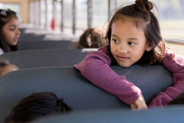 istock Elementary schoolgirl riding school bus 1162215700