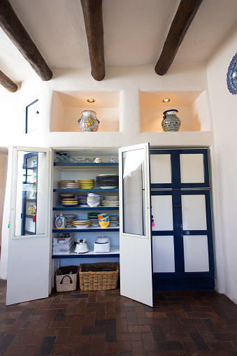 Rustic Southwest USA Kitchen: Brick floor, ceiling beams, and cupboards and fridge. Wide angle. Shot in Santa Fe, NM.