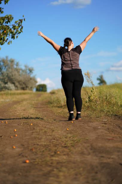 istock Happy woman standing in nature with open hands. 1162217047