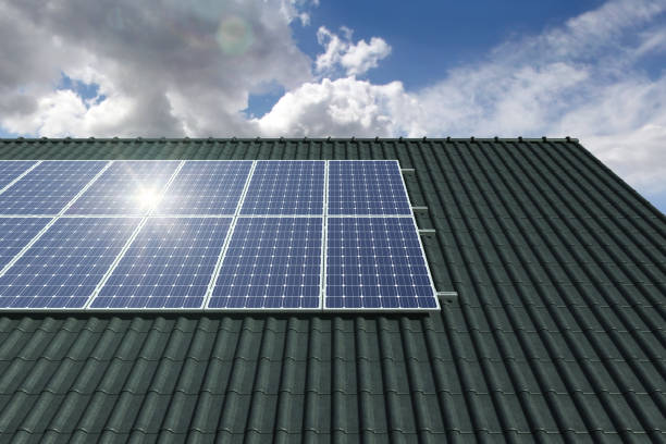 istock Solar panels modules on house roof with clear sky in background 1162217901