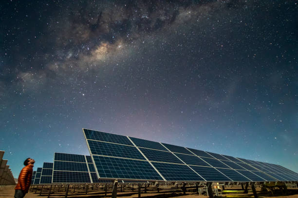 Solar Energy Panels view, a nice technology blue pattern at Atacama Desert arid lands. The solar modules going to the infinity with the Milky Way trying to get energy from the stars on the night sky and converting it into electricity an amazing night view