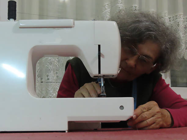 istock Older Woman is Working at Sewing Machine at Home 1162223824