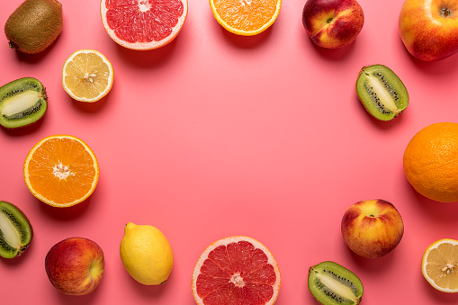 Creative fruit composition on pink background with hard shadows. Summer minimal concept.