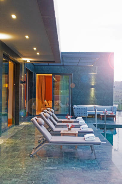 istock Deck chairs on plank floor against swimming pool 1162225190