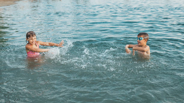 istock Happy children playing in the sea with splashes 1162225745