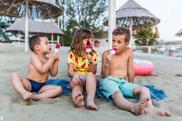 istock Happy kids eating ice cream on the beach 1162225754