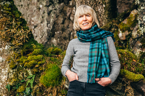 Mature woman in plaid scarf in a natural environment.