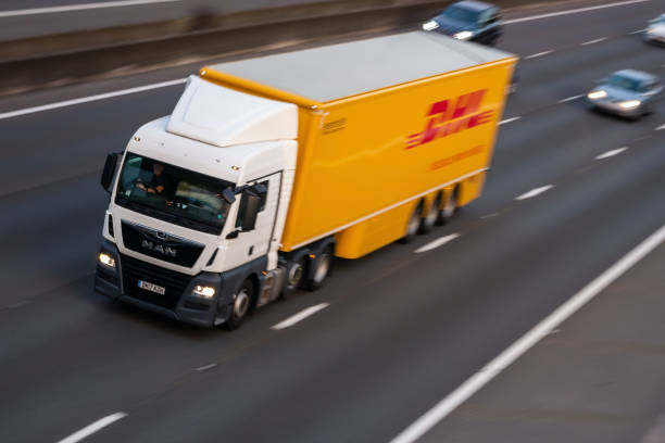 Luton, UK - July 12, 2019: Yellow lorry belonging to German courier company DHL in moton on British motorway M1