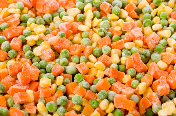 istock Frozen diced vegetables background with carrot, corn and peas. 1162231530