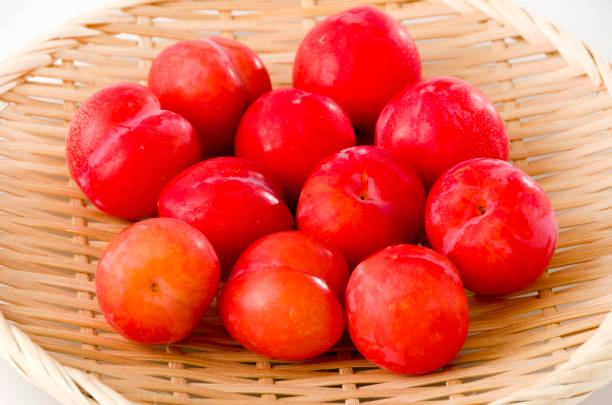 istock Japanese plum (Prunus salicina) on bamboo colander on white background 1162232394
