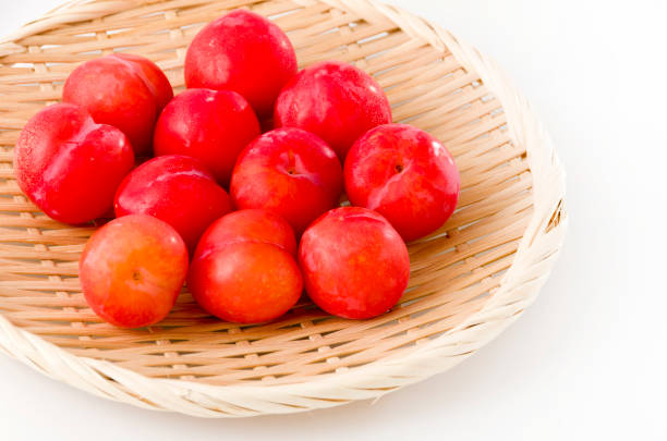 istock Japanese plum (Prunus salicina) on bamboo colander on white background 1162232484