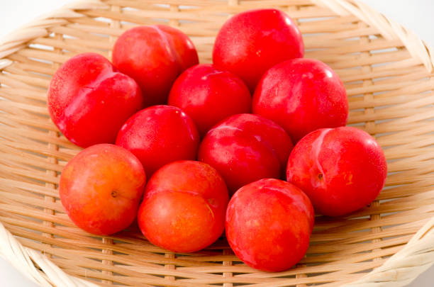istock Japanese plum (Prunus salicina) on bamboo colander on white background 1162232499