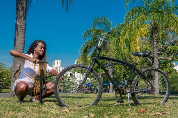 mujer llena el neumático de la bicicleta - brazil bicycle rio de janeiro outdoors fotografías e imágenes de stock